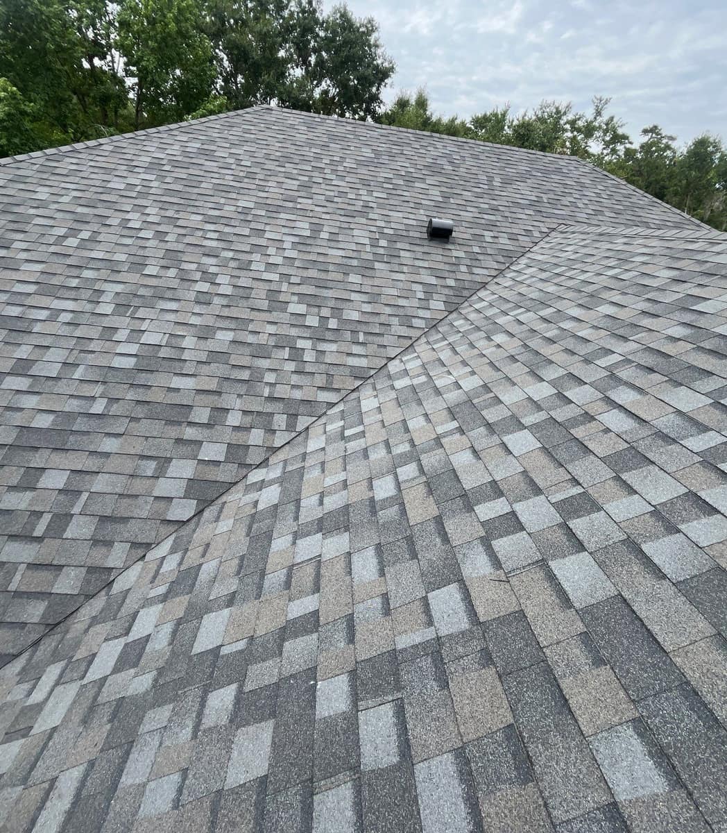 Looking up a valley at the charcoal, gray and tan shingle blend on the Alachua home