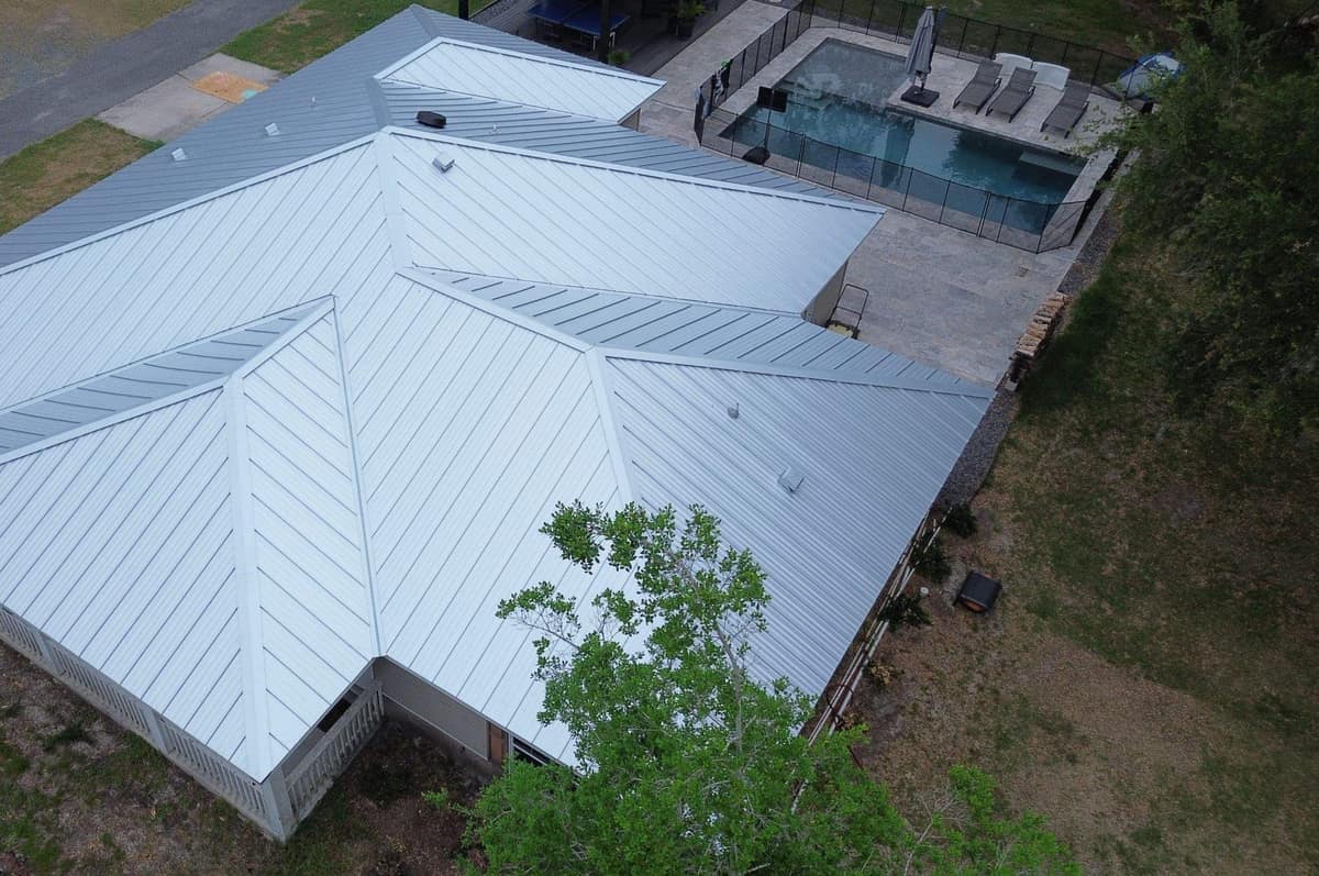 Drone view of a Belleview ranch home with a new light gray standing seam metal roof