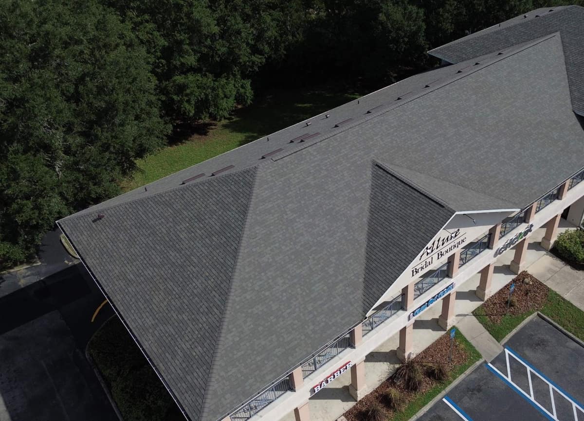 Drone view of the new charcoal shingle roof on a two-story commercial building in Gainesville