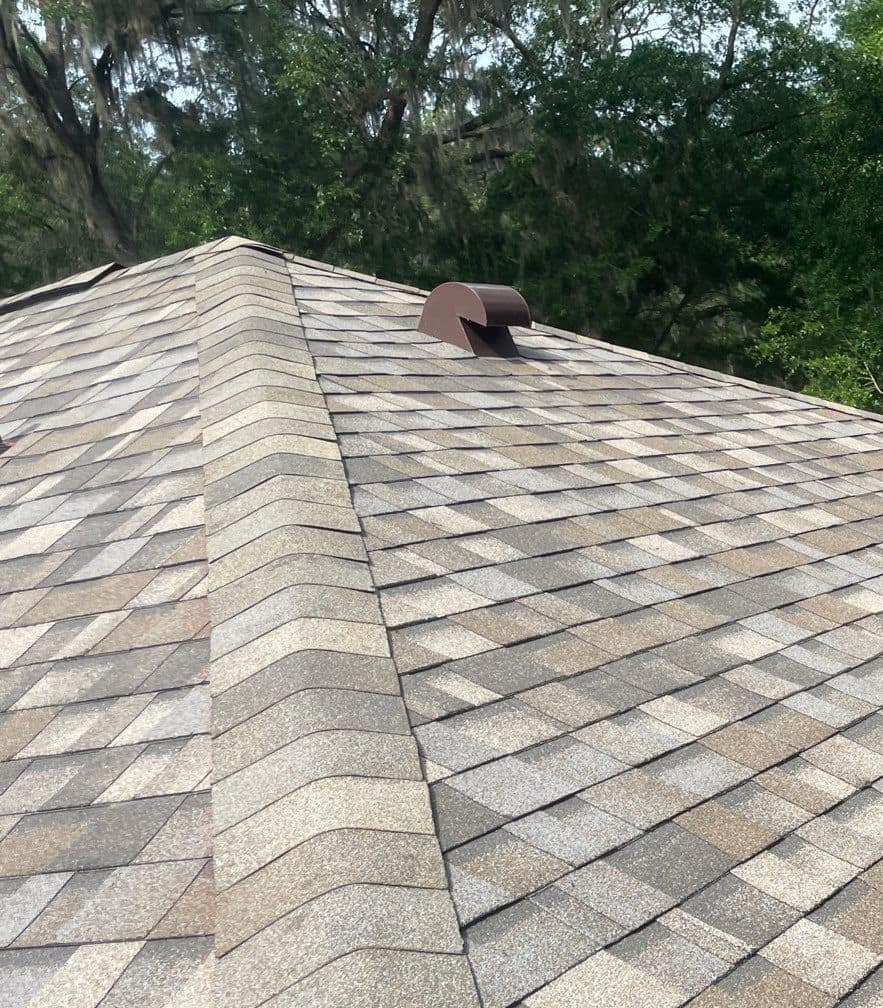 Brown hooded exhaust vent near the top of a capped hip on the Gainesville roof