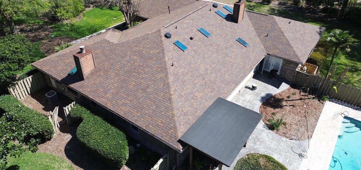 Drone view of the new brown blend shingle roof on a single-story Gainesville home beside the pool