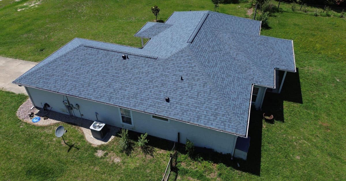Drone view of the whole L-shaped hip roof on a High Springs home with new blue-gray shingles