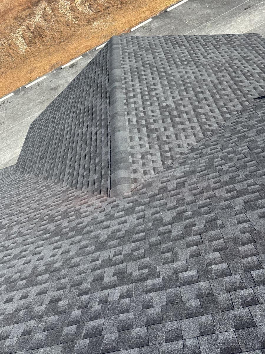 Hipped wing of the new dark gray shingle roof on a Live Oak commercial building
