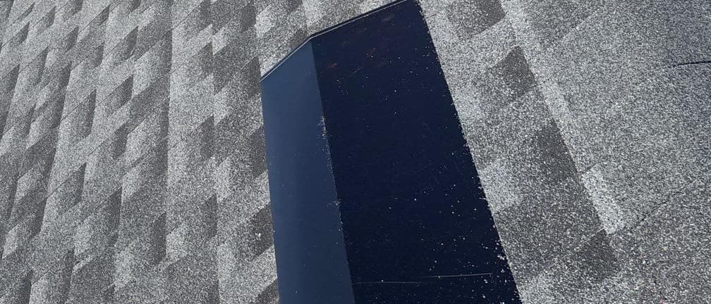 Low rectangular metal roof vent set into the new architectural shingles in Live Oak