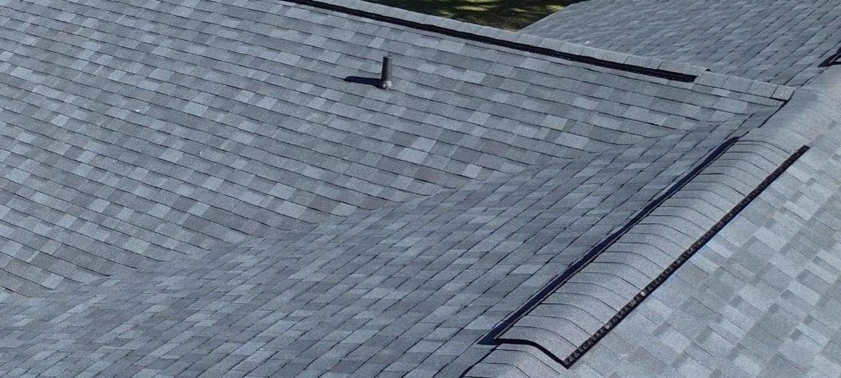 Close view of a ridge vent under cap shingles beside a valley on the Newberry roof