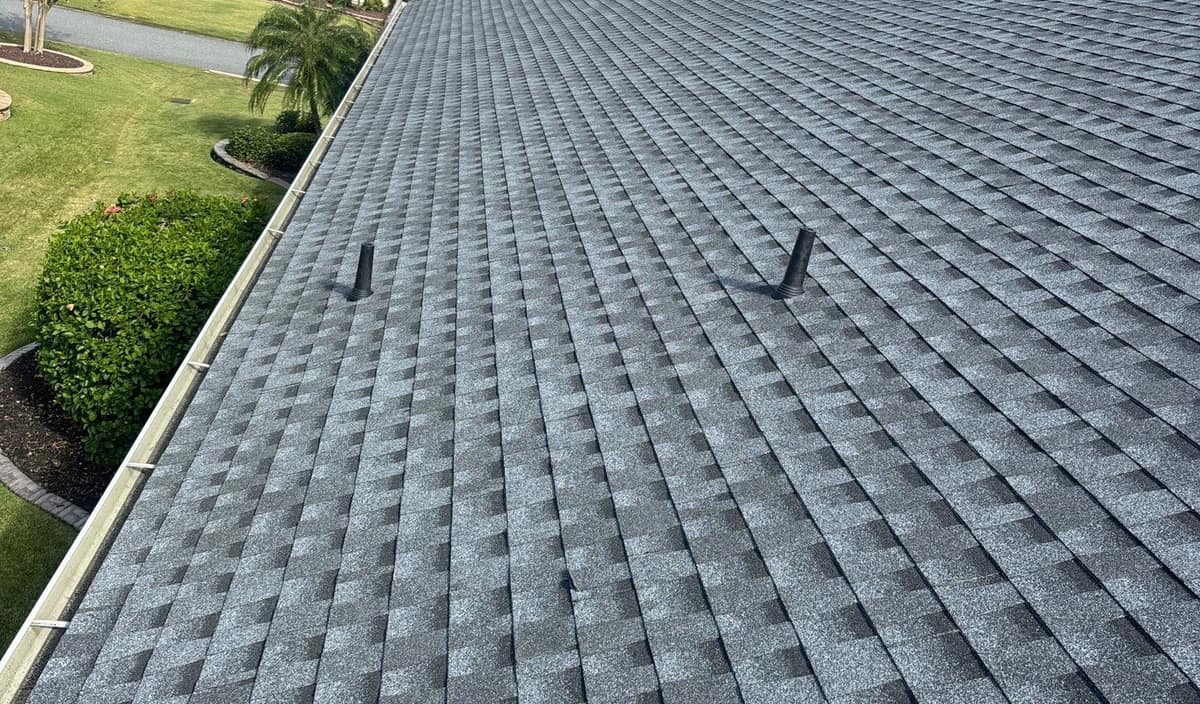 Main slope of the new medium gray shingle roof with two black pipe vents in The Villages