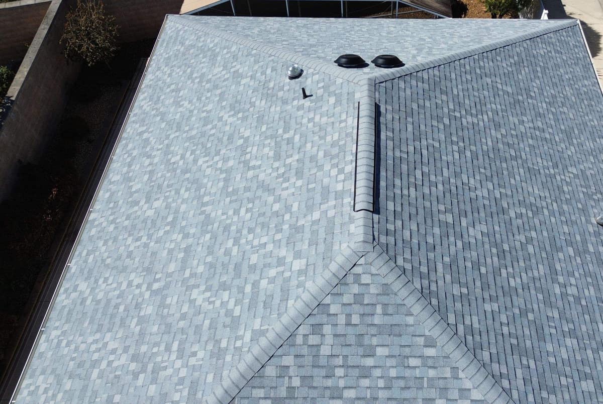Upper slopes of The Villages home with two round black vents, a skylight dome and a pipe vent