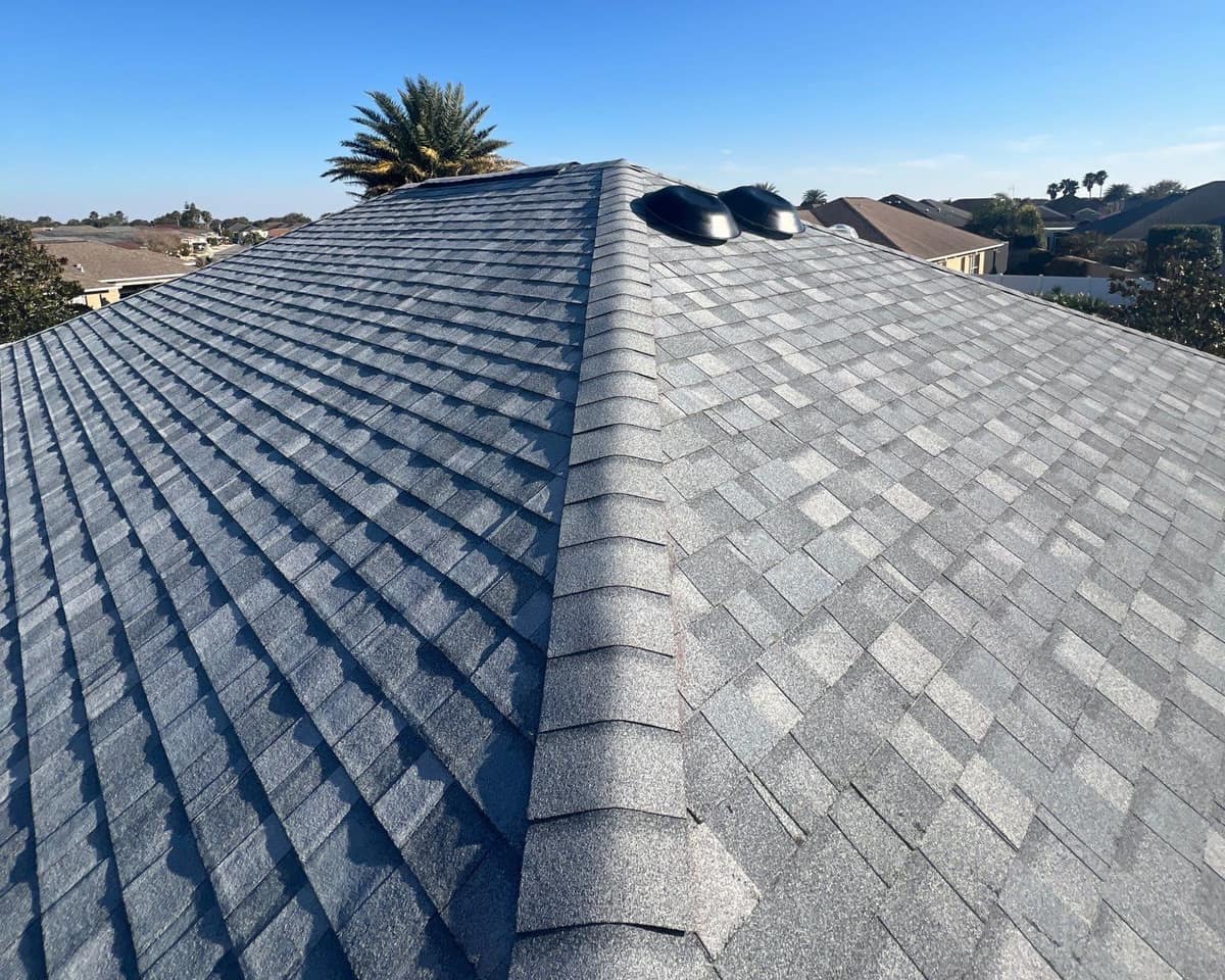 Looking up a capped hip toward the round black vents on the new roof in The Villages