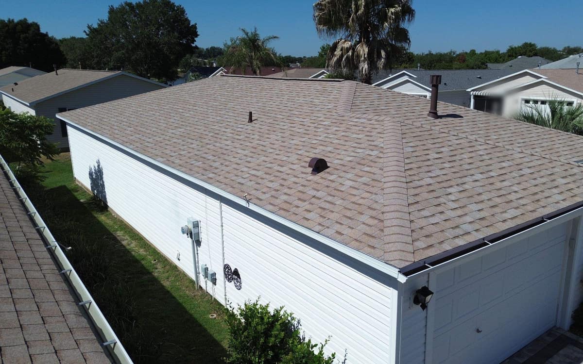 Drone view of a new light tan shingle hip roof on a villa in The Villages, FL