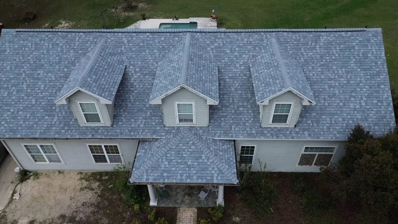 Elevated front view of a Trenton home with a gray shingle roof and three dormers