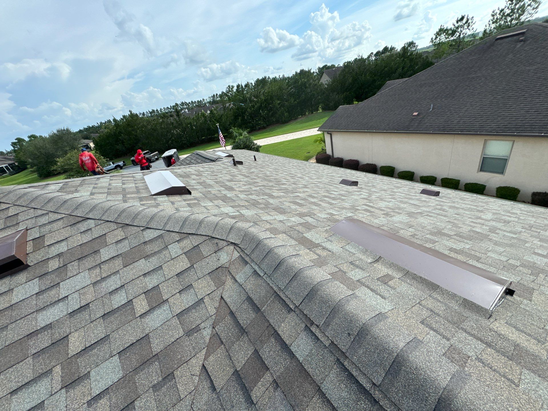 Crew installing Driftwood architectural shingles during an Ocala, FL roof replacement